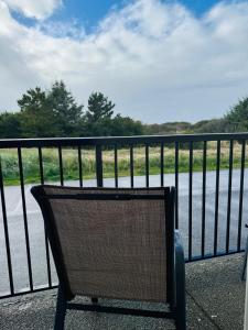 a wicker bench sitting on a balcony overlooking a body of water at Ocean Paradise Hotel & Resort in Ocean Shores +35 photos