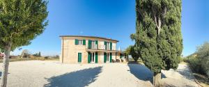 a house on a beach with trees in front of it at Il Grande Cipresso B&B in Castelnuovo +14 photos