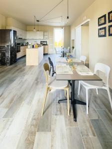 a dining room with a table and chairs and a kitchen at B&B Il Grande Cipresso Recanati in Castelnuovo +21 photos
