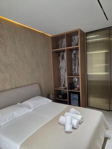 a bedroom with a bed with two towels on it at Lorins Seaside Santorini in Drymades Beach in Gjilek +63 photos