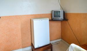 a small television sitting on top of a refrigerator at Ogalis K-coast Hotel in Mtwapa