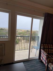 a room with a balcony with sliding glass doors at Ocean Paradise Hotel & Resort in Ocean Shores