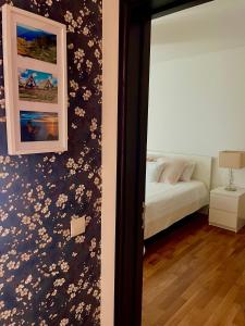 a bedroom with a bed and a wall with flowers at Rodamar Apartment Forum Funchal in Funchal