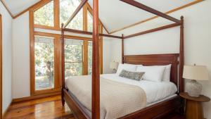 a bedroom with a canopy bed and windows at Raven by AvantStay Entertainers Dream w Pool Hot Tub Game Room 9 BRs in Sullivans Island +38 photos