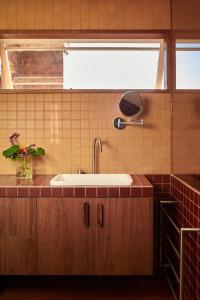 a bathroom with a sink and a mirror and a window at Cosy Cottage in North Fitzroy in Melbourne +9 photos