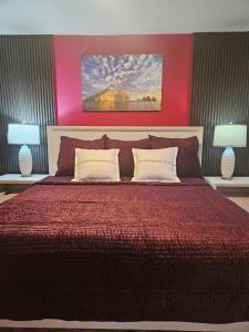 Casa Flor del Desierto في لوريتو: غرفة نوم بسرير احمر كبير مع مصباحين