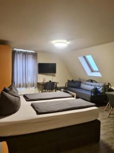 a bedroom with a large bed and a couch at Hotel Mythos "Alle Zimmer mit Kochnische - Apartments mit Küche" in Markgröningen