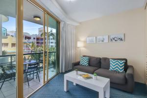 a living room with a couch and a table at Landmark 1 Bedroom Beachside Escape in Mooloolaba