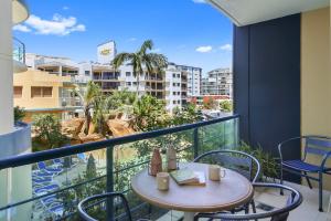 a balcony with a table and chairs and a view of a city at Landmark 1 Bedroom Beachside Escape in Mooloolaba