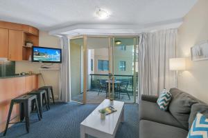 a living room with a couch and a table at Landmark 1 Bedroom Beachside Escape in Mooloolaba