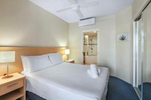 a bedroom with a large white bed with a nightstand and a bed sidx sidx at Landmark 1 Bedroom Beachside Escape in Mooloolaba +12 photos