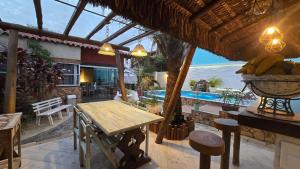 a patio with a table and a swimming pool at Recanto das Borboletas in Búzios