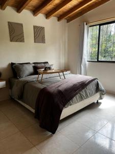 a bedroom with a bed with a table on it at Casa Moderna en el Bosque Jacuzzi y Deck Privado in Mazo