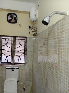 a bathroom with a toilet and a window at JM Niwas in Guwahati