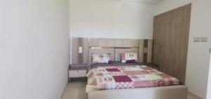 a bedroom with a bed with pillows on it at Apartment222 2 rooms Al Bousten Hammamet in Hammamet Sud +12 photos