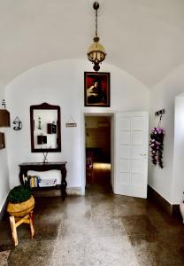 een kamer met een witte deur, een tafel en een kroonluchter bij Gabriele Apartment Salento in Gallipoli