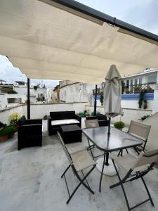 een terras met een tafel, stoelen en een parasol bij Gabriele Apartment Salento in Gallipoli +23 foto's