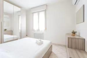 a white bedroom with a bed and a mirror at Patty Sweet Home, Cattolica Centro in Cattolica