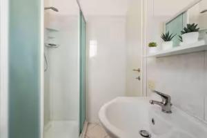 a white bathroom with a sink and a shower at Patty Sweet Home, Cattolica Centro in Cattolica