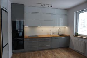 ヴィエリチカにあるVIP Apartments Victoriaの白いキャビネットと木製のカウンタートップを備えたキッチン