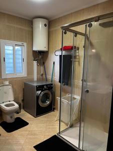a bathroom with a washing machine and a toilet at Magnifique appartement villa in Martil