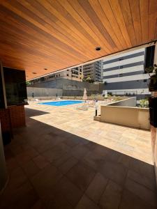 une vue d'une piscine avec un plafond en bois dans l'établissement Flat no coração de Alphaville, à Barueri