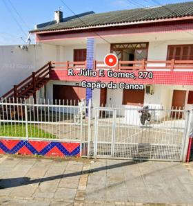 a white fence in front of a building at Sobrado terreo aconchegante in Capão da Canoa