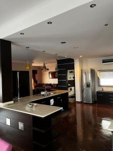 a large kitchen with a counter and a refrigerator at Magnifique appartement villa in Martil +9 photos