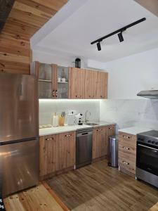 a kitchen with wooden cabinets and a stainless steel refrigerator at Villa Jelterra in Uskoci +10 photos