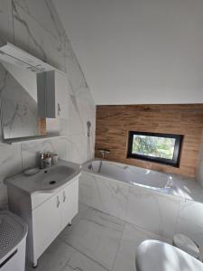a white bathroom with a tub and a sink at Villa Jelterra in Uskoci