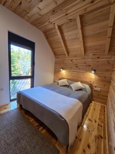 a bedroom with a large bed in a wooden room at Villa Jelterra in Uskoci