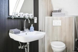 巴尔特鲁姆Haus Deichbrise的浴室里有洗手池、马桶和镜子。
