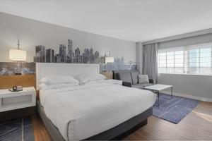 a bedroom with a large white bed and a living room at World of Blue 711 I Beautiful King Hotel Room in Secaucus