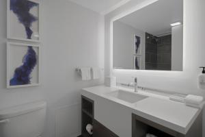 a white bathroom with a sink and a mirror at World of Blue 711 I Beautiful King Hotel Room in Secaucus +16 photos