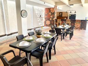 a dining room with black tables and chairs at Villa vacacional piscina en playa dormida in Santa Marta