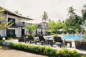 een hotel met stoelen en een zwembad bij Ocean 101 Beach Resort in General Luna