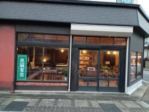 Arita民宿有田 Arita Guesthouse的商店前方设有玻璃窗和桌子