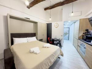 a bedroom with a large bed with towels on it at Centro storico- Suite silenziosa, Wi-Fi & Netflix in Varese