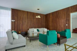 a living room with two chairs and a couch at Casa Orbit AC Pool Jacuzzi Central Location in Oaxaca City