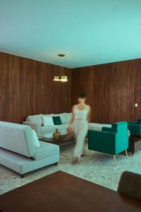 a woman is walking through a living room at Casa Orbit AC Pool Jacuzzi Central Location in Oaxaca City