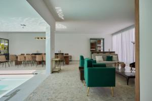 a living room with green chairs and a table at Casa Orbit AC Pool Jacuzzi Central Location in Oaxaca City