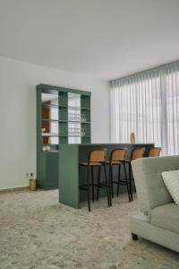 a living room with a green counter and chairs at Casa Orbit AC Pool Jacuzzi Central Location in Oaxaca City +65 photos