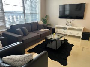 a living room with a couch and a tv at Downtown Memphis Luxury Condo in Memphis
