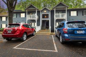 Zwei Autos parkten auf einem Parkplatz vor einem Haus in der Unterkunft Crest at East Cobb 1826B I Spacious 2Bd 2Bt in Marietta