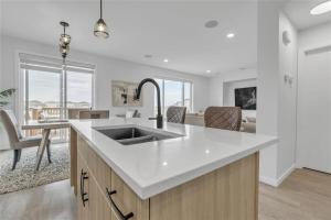 uma cozinha com pia e uma sala de estar em Lakeview at Prairie Pointe em Winnipeg