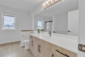 um banheiro branco com uma pia e um vaso sanitário em Lakeview at Prairie Pointe em Winnipeg mais 51 fotografias