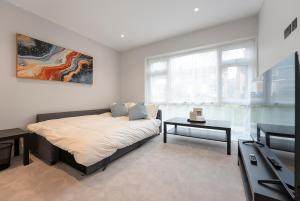 een slaapkamer met een bed, een tv en een tafel bij Modern High Spec Home in Titsey