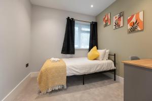 een kleine slaapkamer met een bed en een raam bij Modern High Spec Home in Titsey