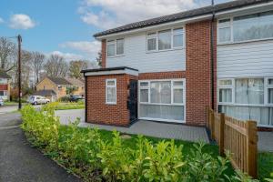 een stenen huis met een veranda en een hek bij Modern High Spec Home in Titsey