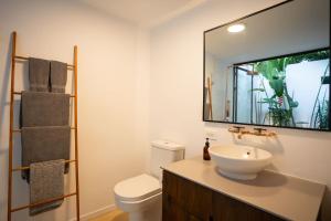 a bathroom with a sink and a toilet and a mirror at Nalu Nosara Pool Villa Sombra in Nosara +8 photos